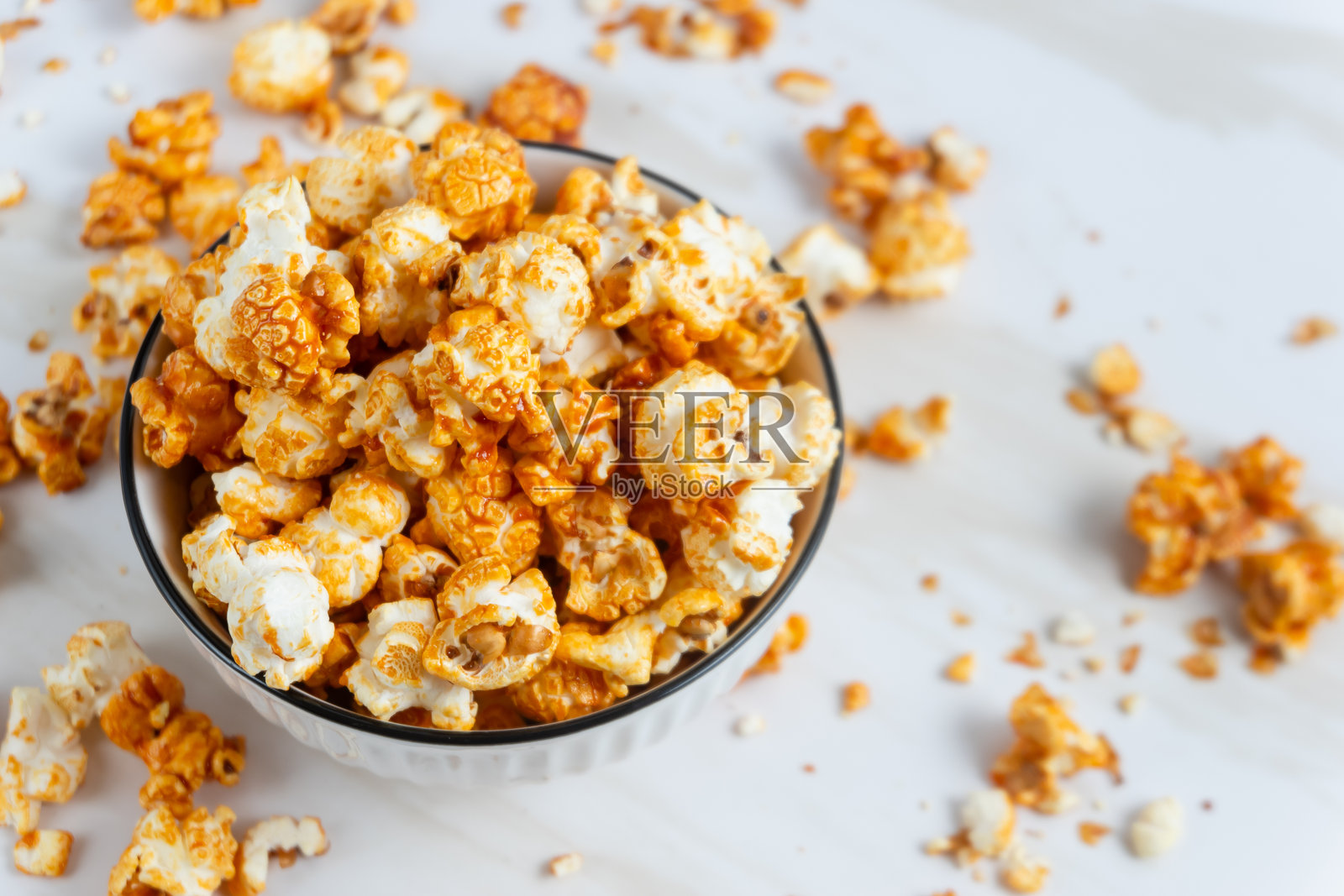 白色碗中的焦糖爆米花。照片摄影图片