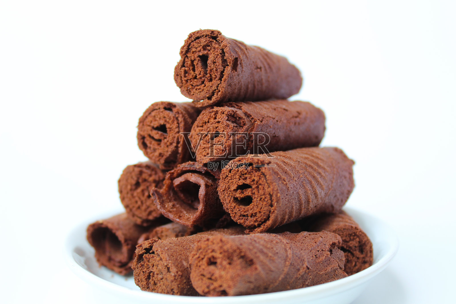 印尼传统小吃，巧克力味的蛋卷。薄薄的煎饼卷起后切成段。甜味。背景为白色。照片摄影图片