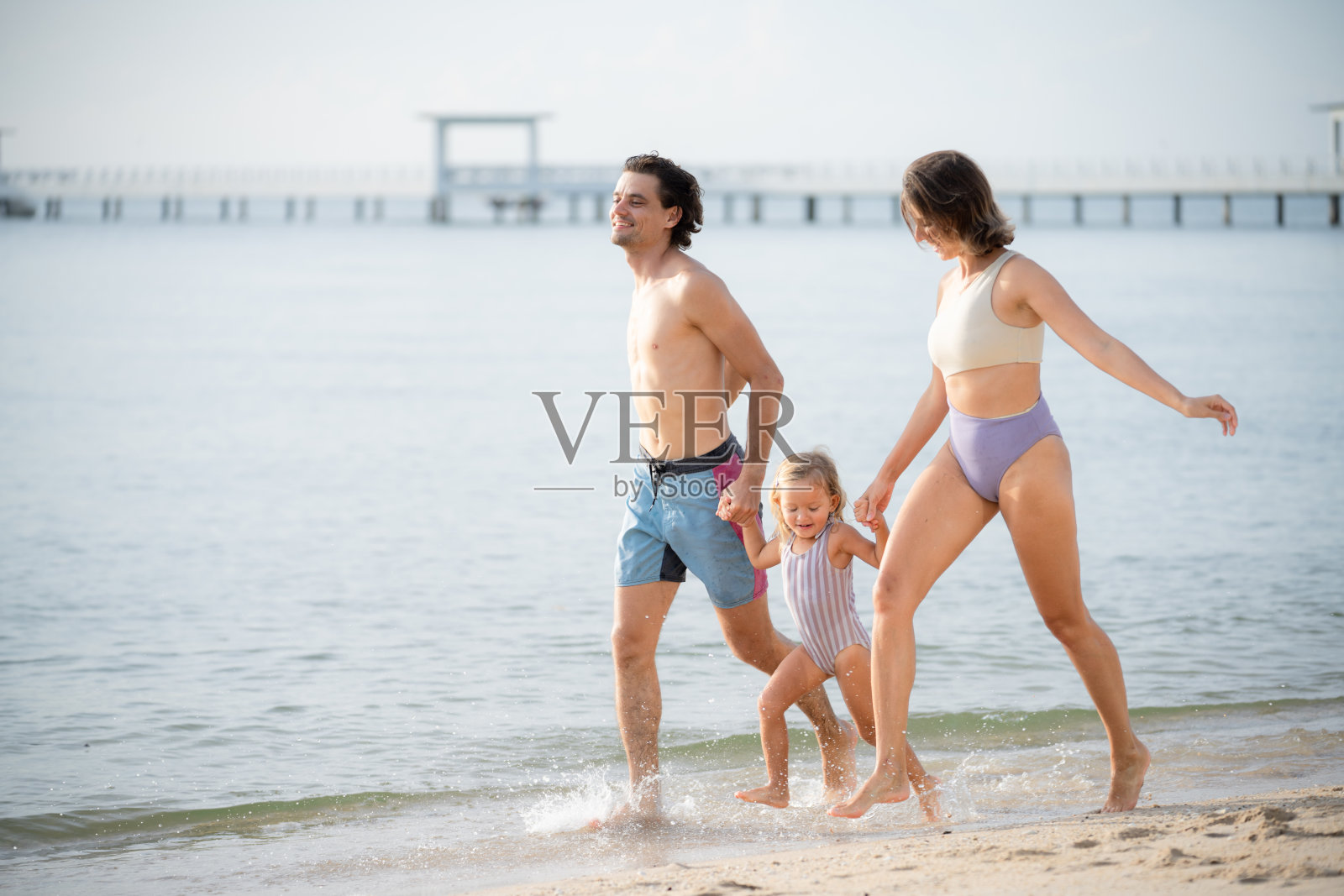 快乐的家庭假期在海滩上。照片摄影图片