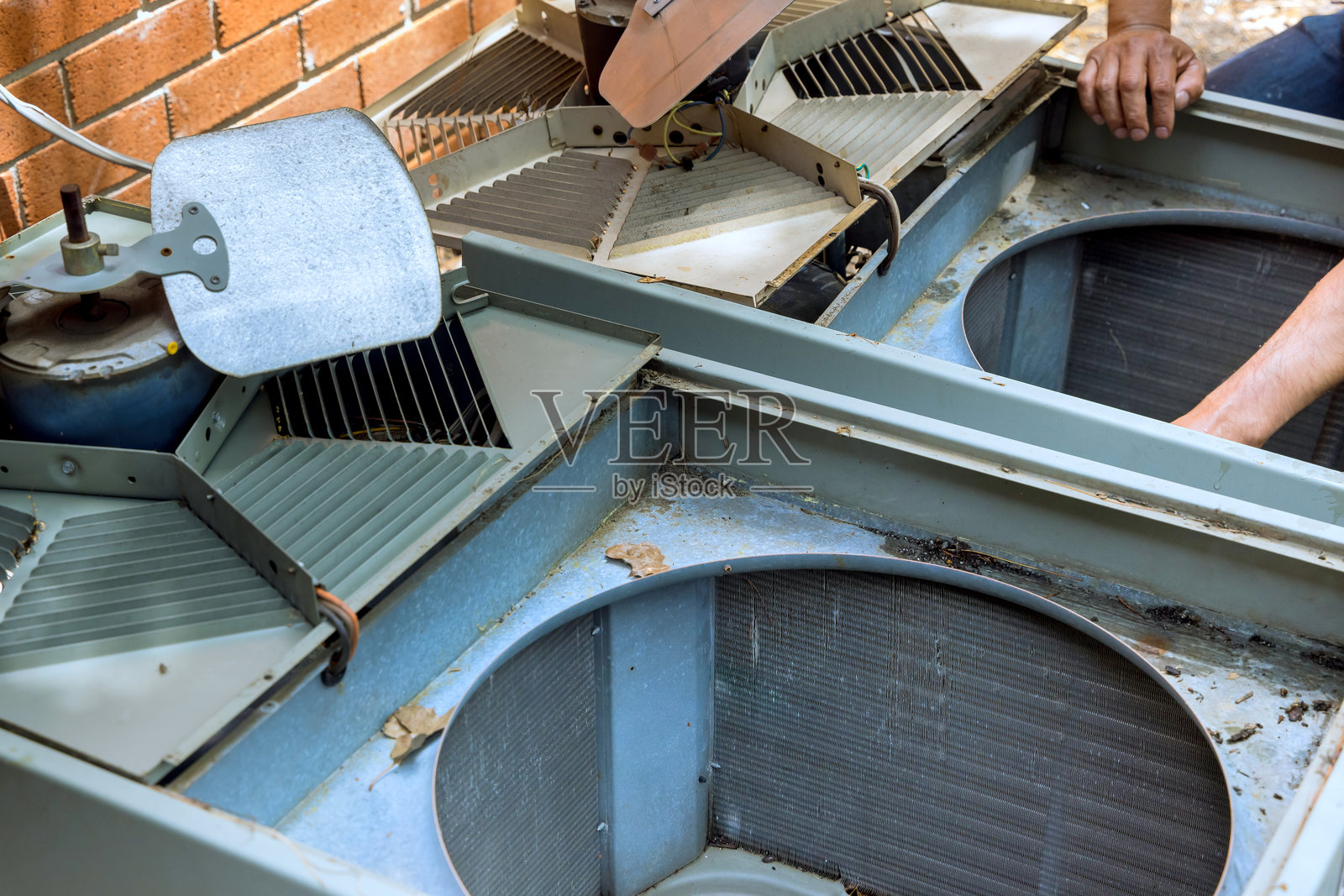 员工在户外机组上进行空调的服务维修和保养工作。照片摄影图片