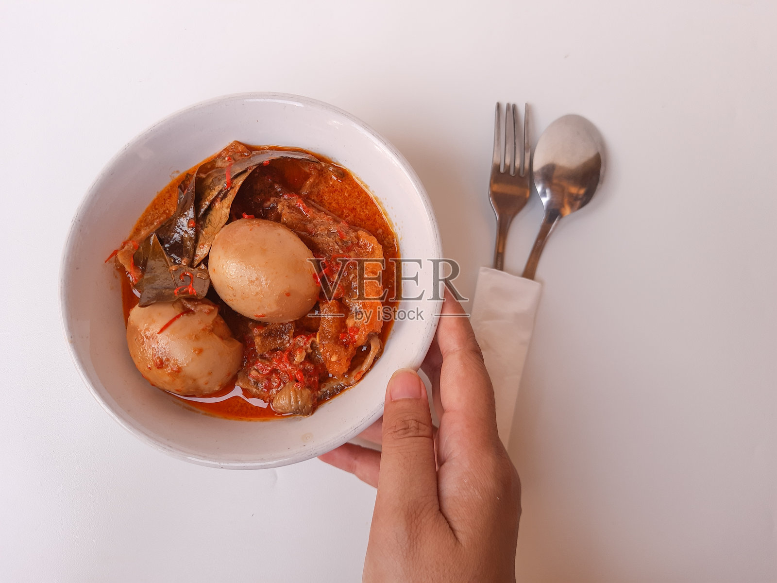 印尼菜，称为 sambal goreng ati。由鸡胗、辣椒、煮鸡蛋、椰奶和牛皮脆片（牛的软内皮）组成。是开斋节的特色菜肴。选择性聚焦。照片摄影图片