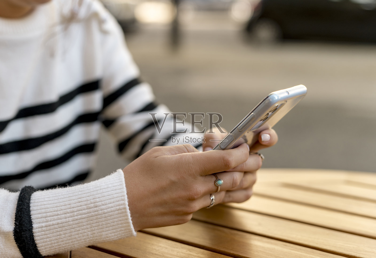 一个女人在咖啡馆用手机发短信的特写照片摄影图片