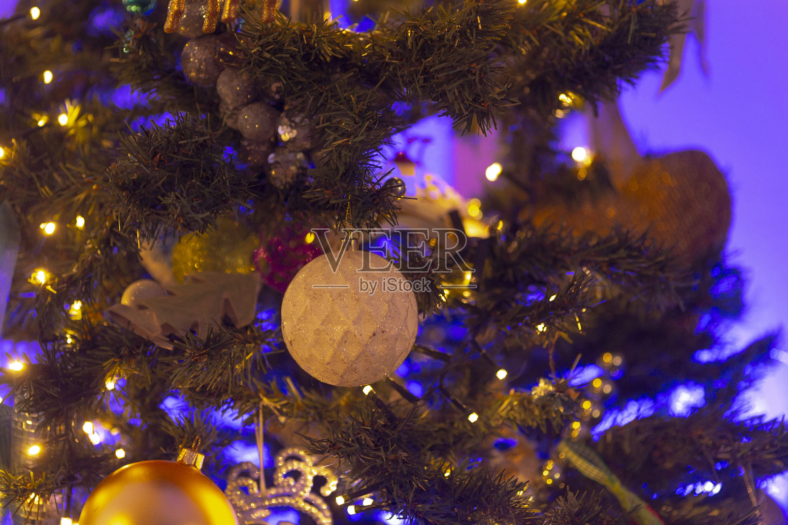 特写镜头的圣诞树，装饰着紫色灯光和装饰品照片摄影图片