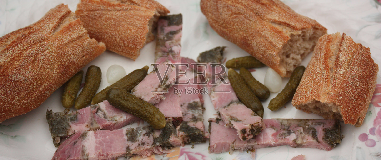 法式香肠的法棍三明治，配以香菜火腿和腌黄瓜照片摄影图片