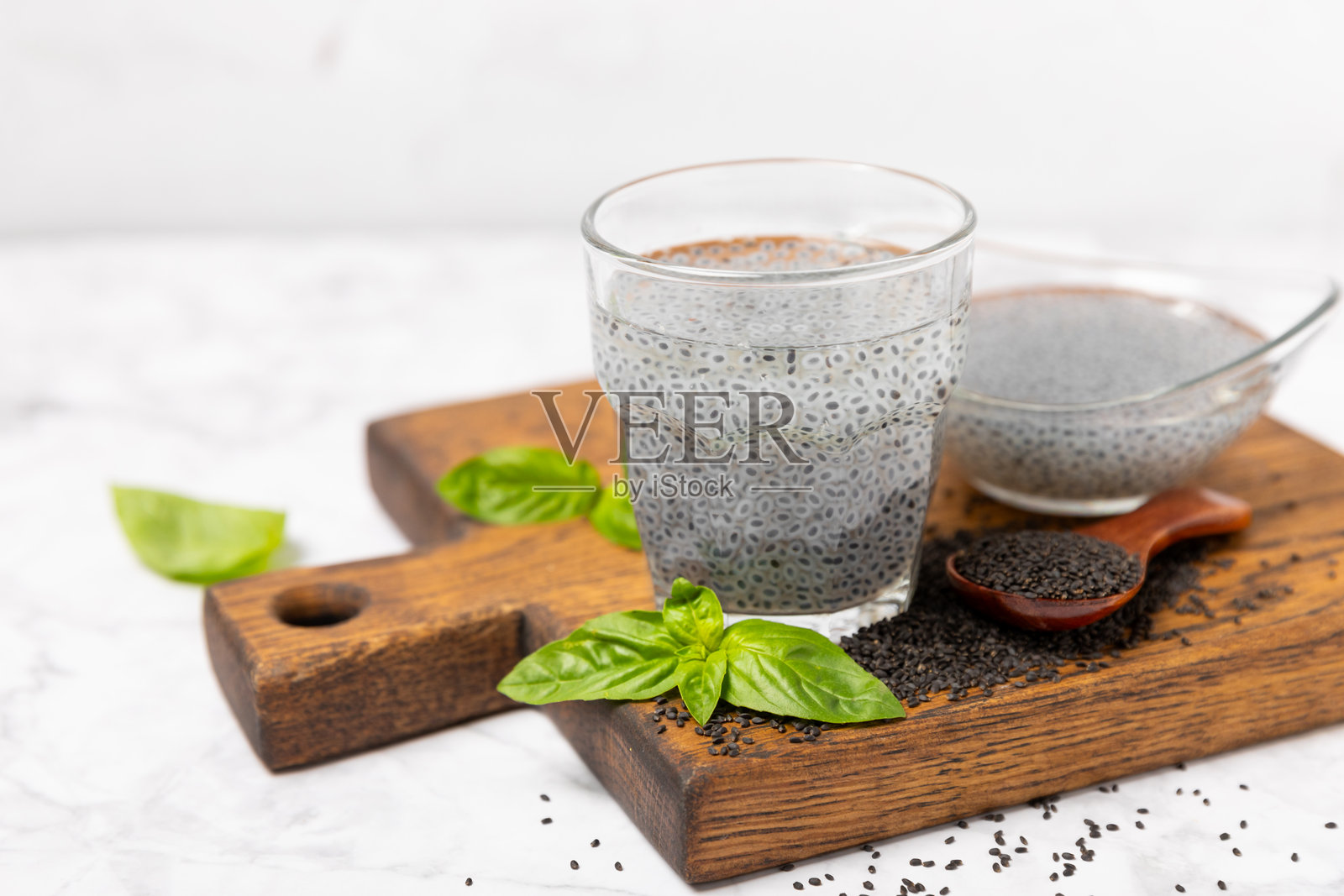 有纹理的木质背景上的罗勒种子。特写。超级食品。Ocimum basilicum。有机罗勒种子。selasih。留白空间。照片摄影图片