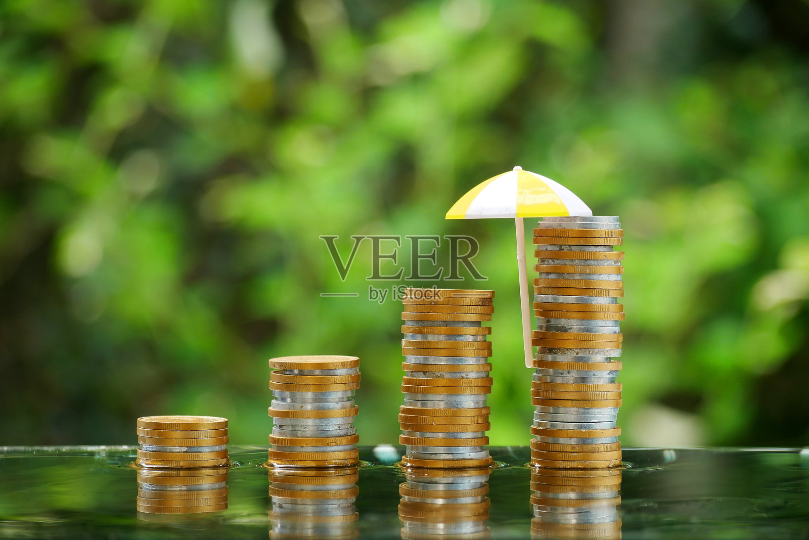 桌子上堆满硬币的小红伞。金融安全和投资的概念，保护。照片摄影图片