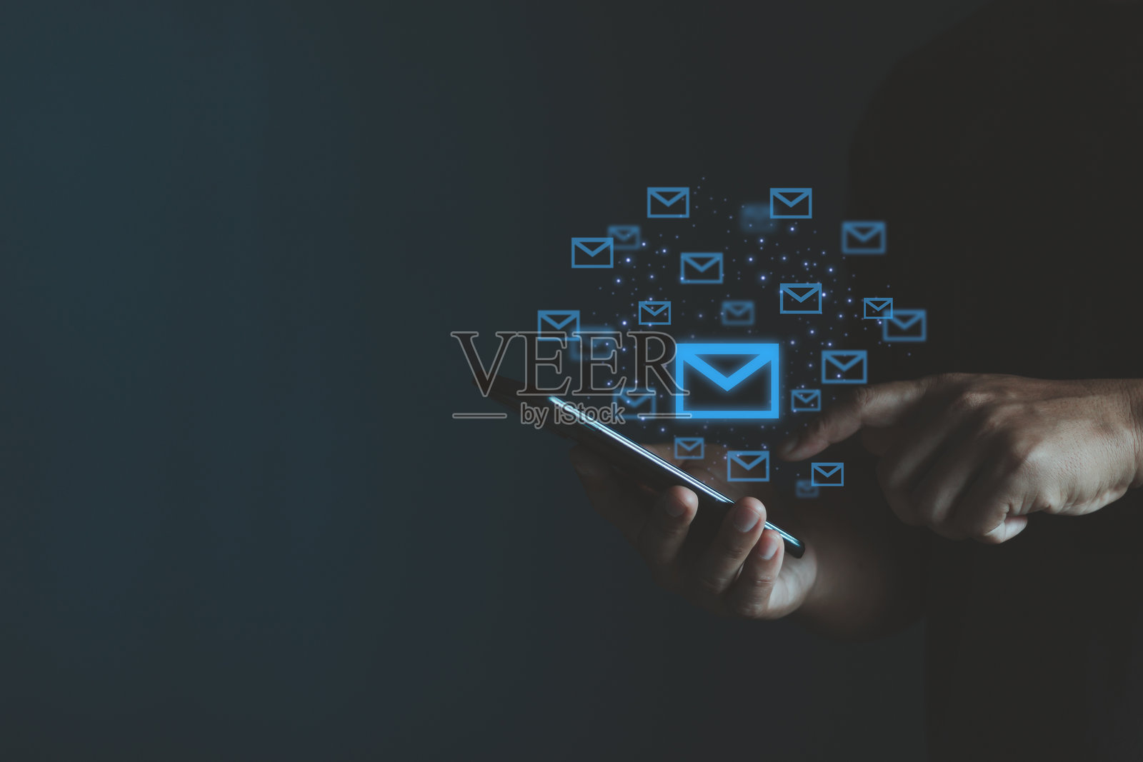 一个年轻的亚洲男子正在用手机发送电子邮件，手机上闪烁着电子邮件图标。商业电子邮件沟通和数字营销。信息技术概念。照片摄影图片