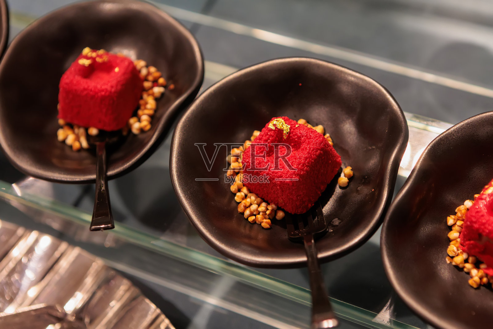 美味的小红丝绒蛋糕，配有奶油奶酪糖霜和磨碎的奶酪照片摄影图片