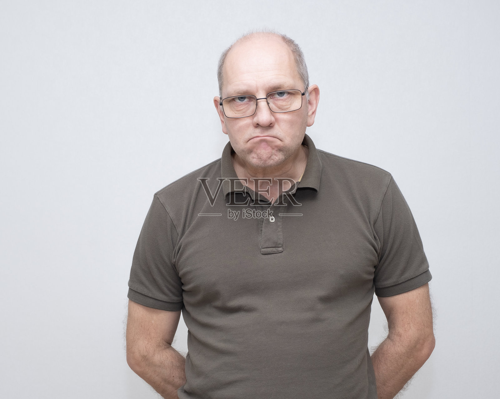 54岁的白人男性，面露不悦，严肃地看着镜头。照片摄影图片