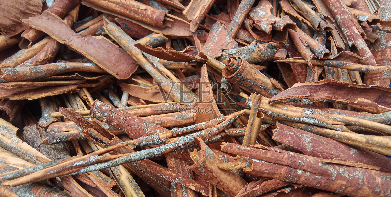 肉桂（Cinnamomum cassia）。一堆干燥和粉碎的肉桂棒，带有剩余的外皮或未完成的刮削。照片摄影图片