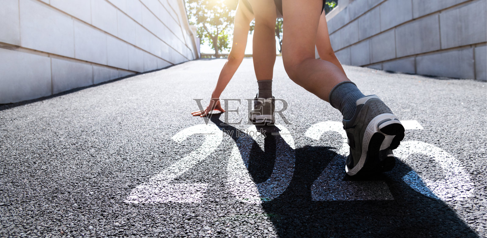 年轻的运动员准备跑步，路面上写着2025的新年数字照片摄影图片