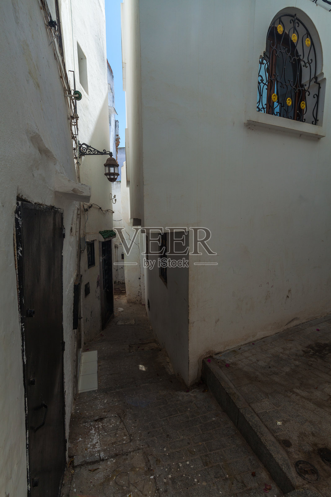 狭窄、昏暗的巷道夹在粉刷一新的建筑之间，营造出古镇环境中的神秘与吸引力。照片摄影图片