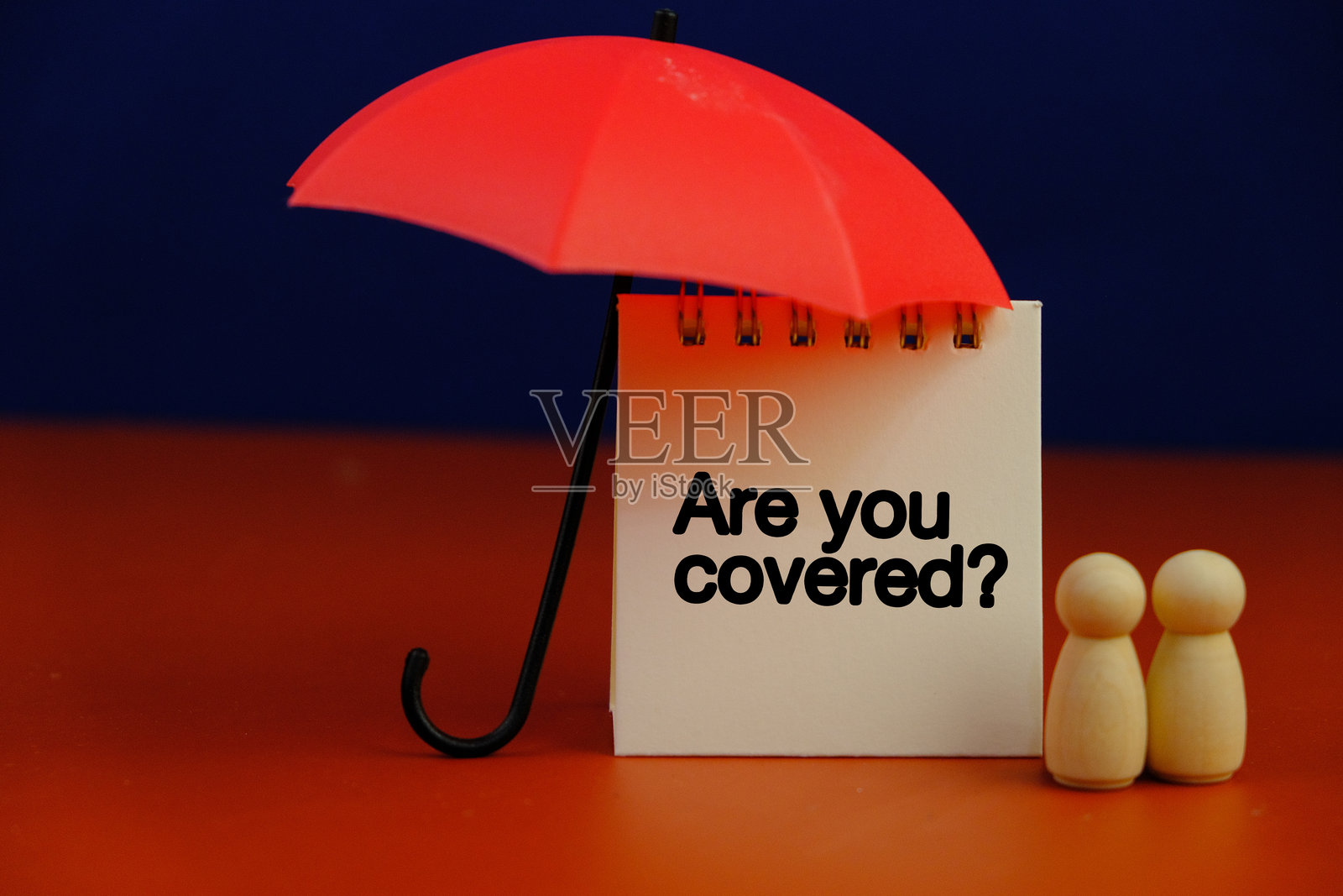 一本写着“你有保障吗？”的问题笔记本和一把伞。留有文本空白。保险保障概念。照片摄影图片