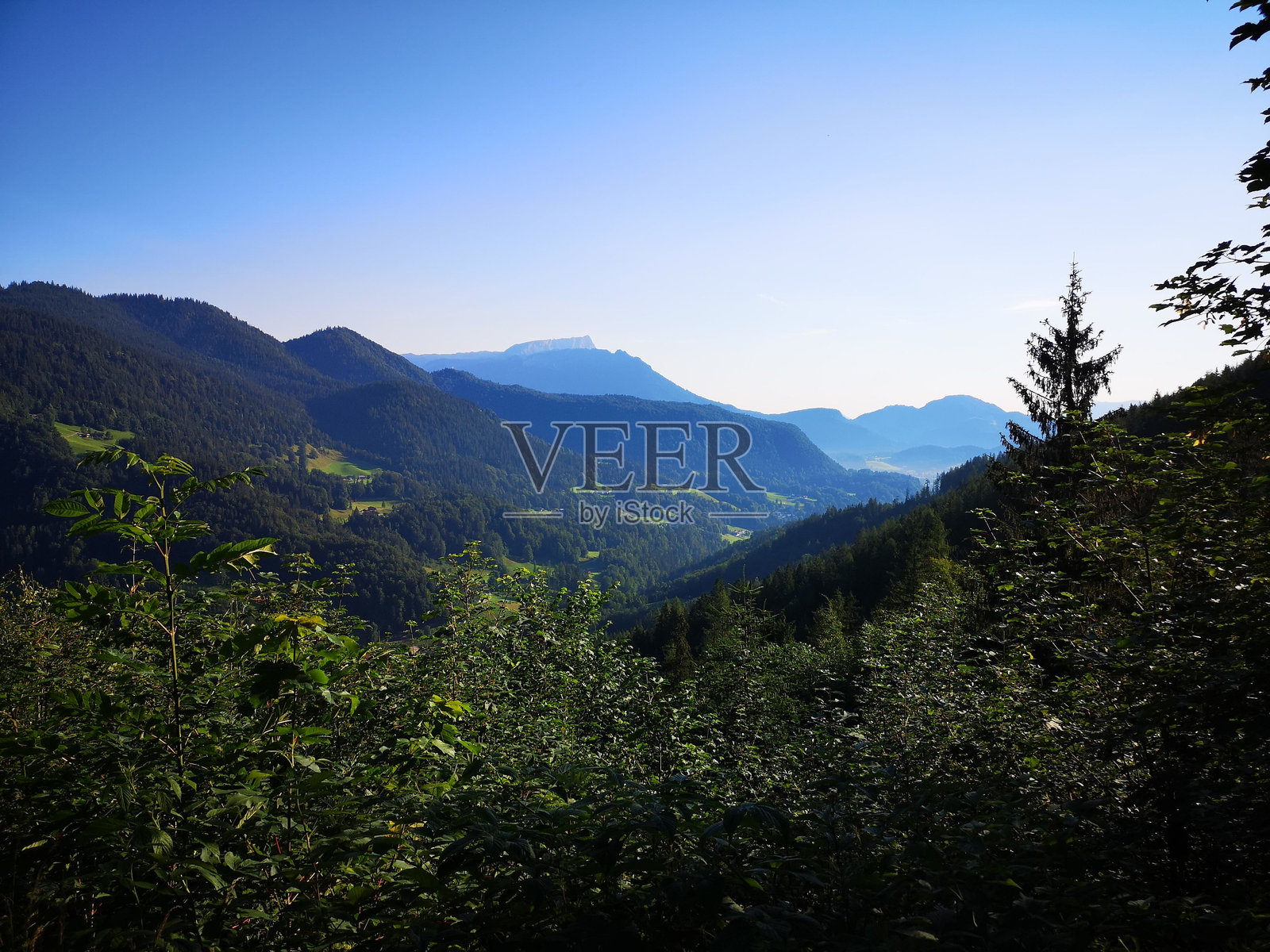 青翠的山谷风景，四周被群山环绕，蓝天映衬下显得格外迷人照片摄影图片