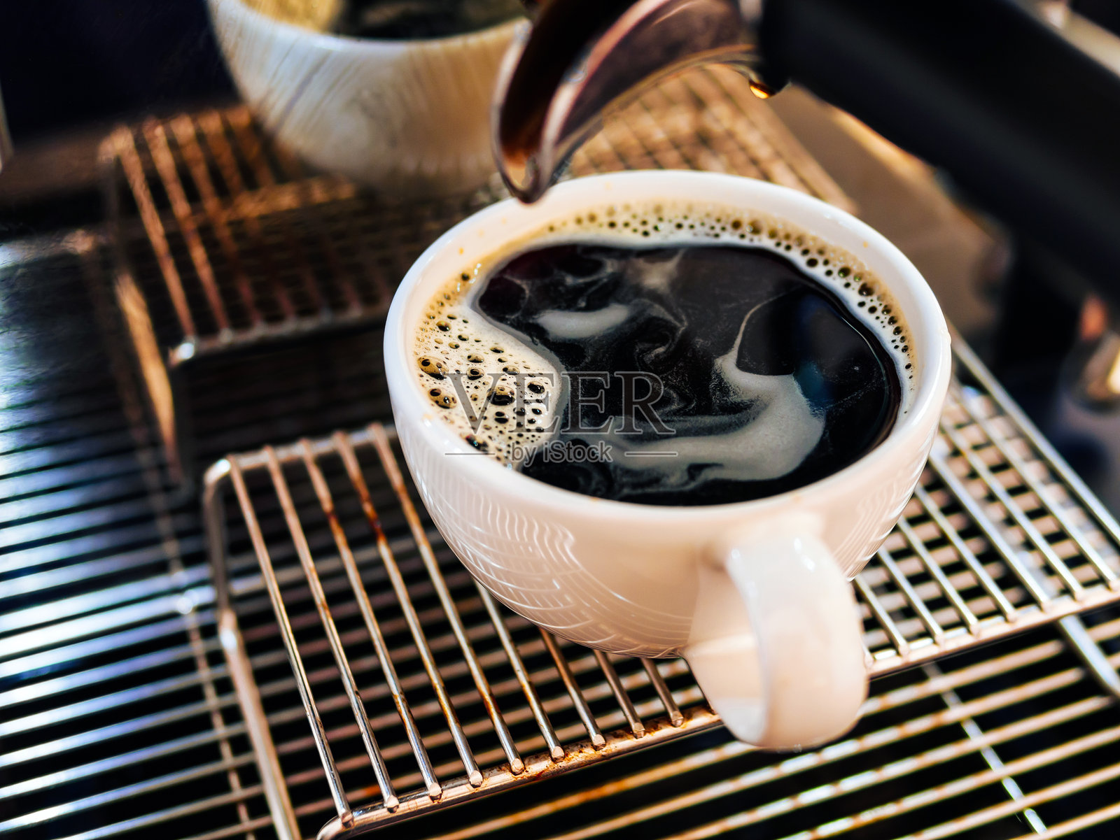 美式咖啡从咖啡机倒入杯子的特写。专业的黑咖啡冲泡。照片摄影图片