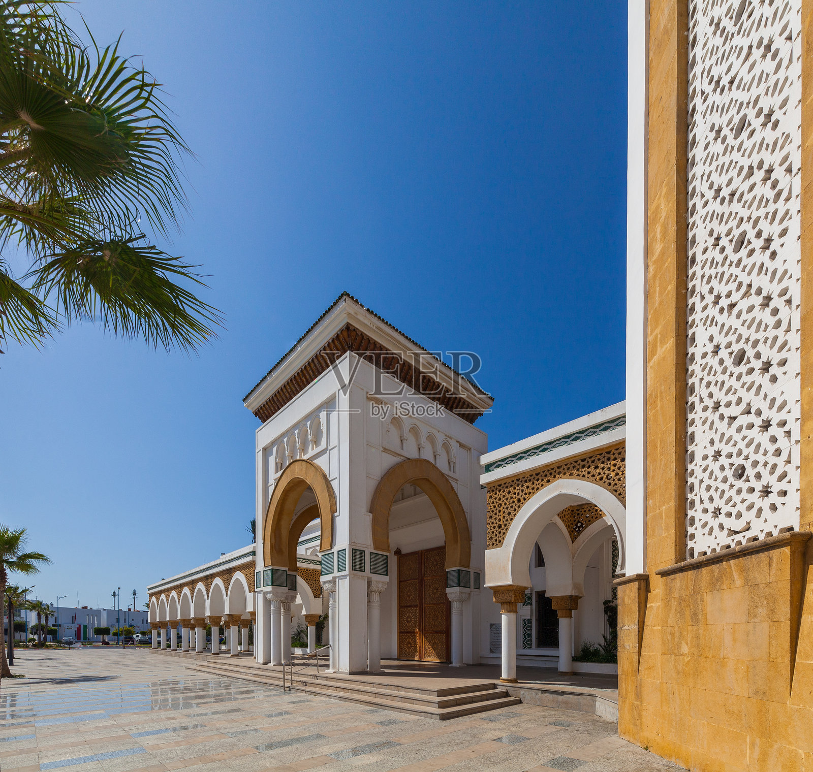 宏伟的清真寺，配有高耸的宣礼塔和对称的外立面，四周环绕着棕榈树和宽敞的广场，形成了一个引人注目而宁静的建筑地标。照片摄影图片
