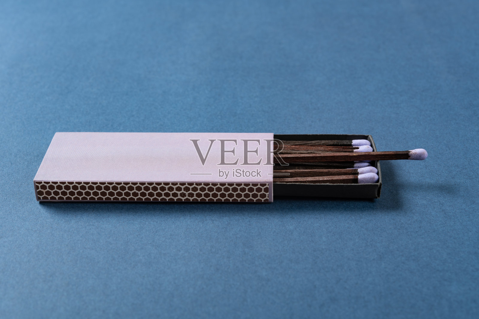 蓝色背景下的水平构图紫丁香色火柴盒的侧面视角照片摄影图片