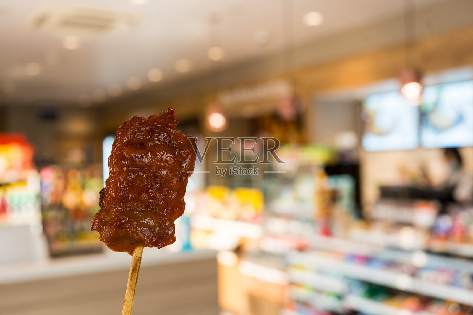 手握泰式烤鸡肉串。照片摄影图片