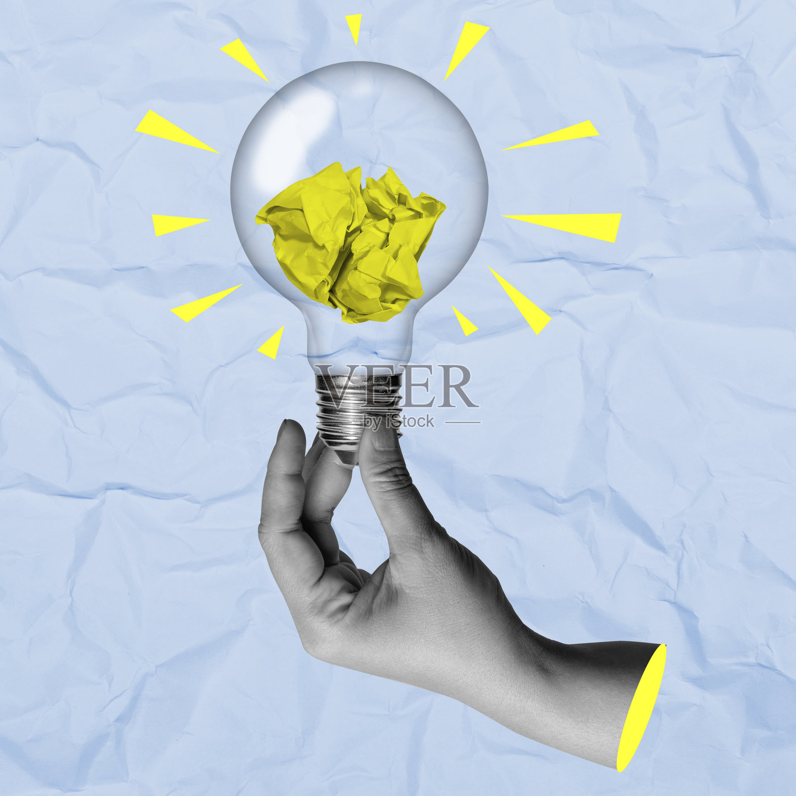 一只手握着一个装有皱纸的灯泡，背景为彩色。照片摄影图片