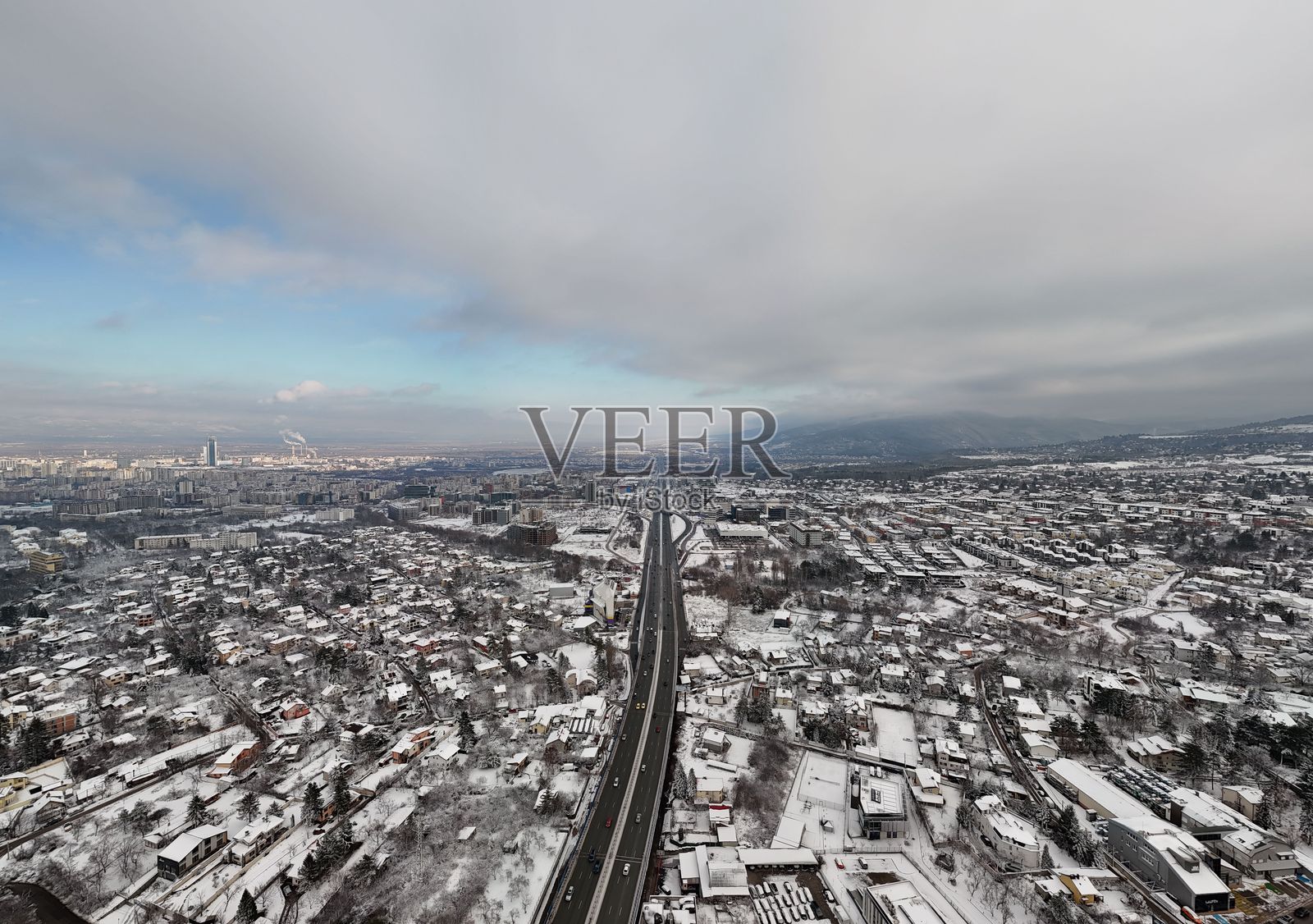 布加勒斯特在阴云密布的天空下被雪覆盖的城市景观。照片摄影图片