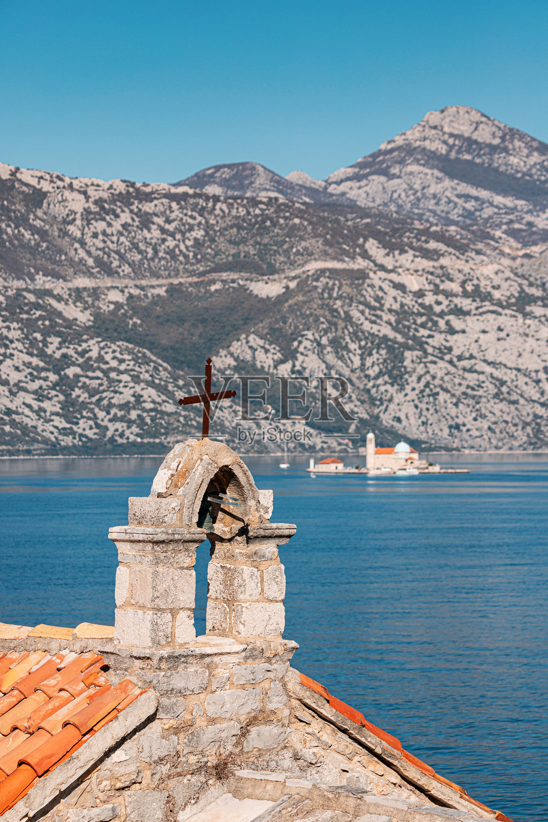 石头教堂配有陶瓦屋顶和钟楼，矗立在海岸上，提供科托尔湾及其岛屿的美丽景色，黑山观光。照片摄影图片