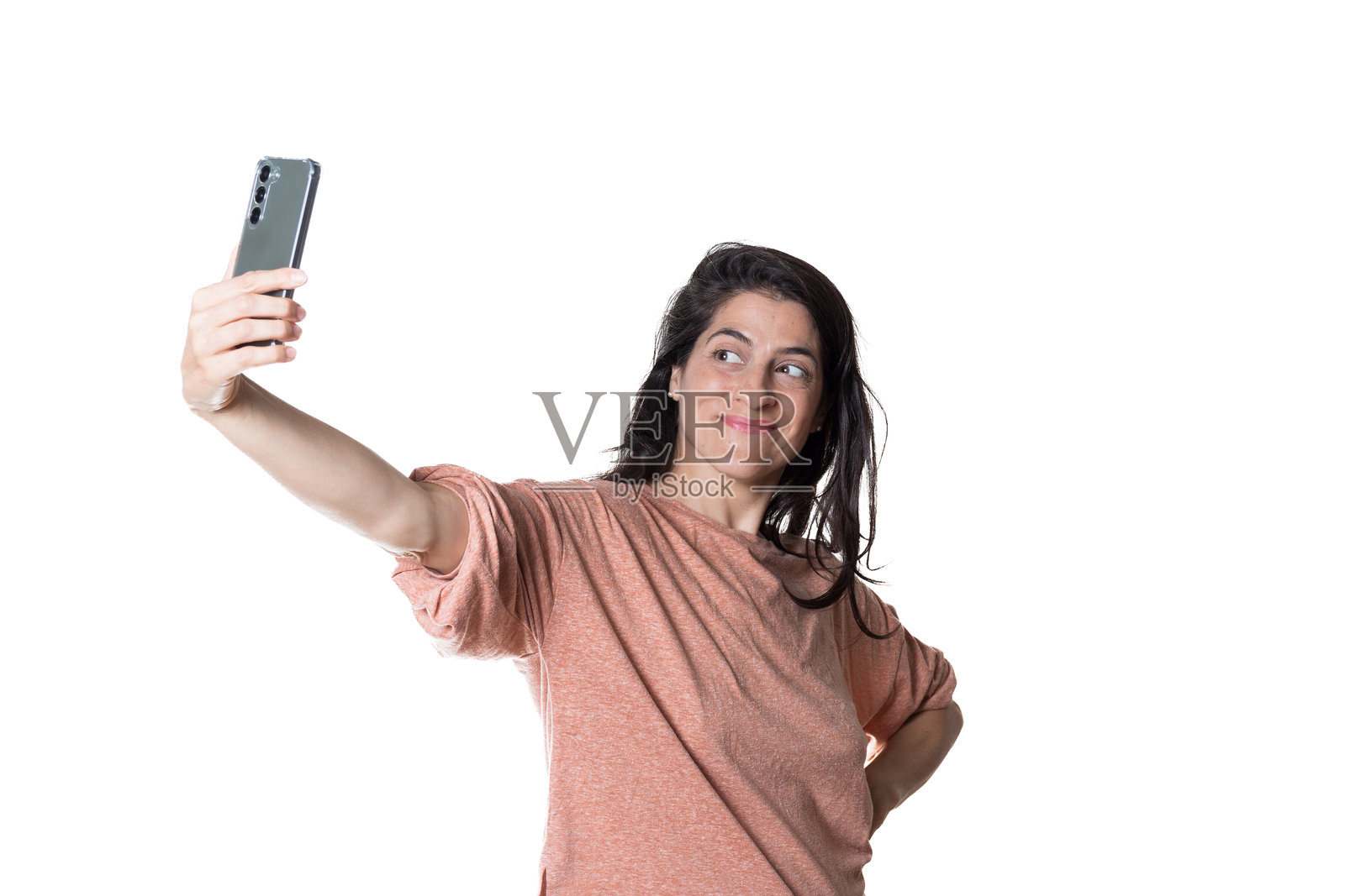 白色背景下的女性用智能手机自拍。照片摄影图片