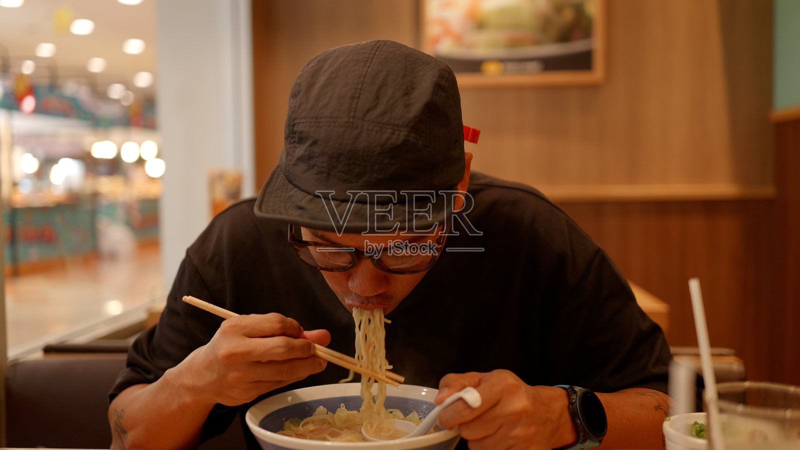 亚洲饥饿男子正在吃拉面。4K。照片摄影图片