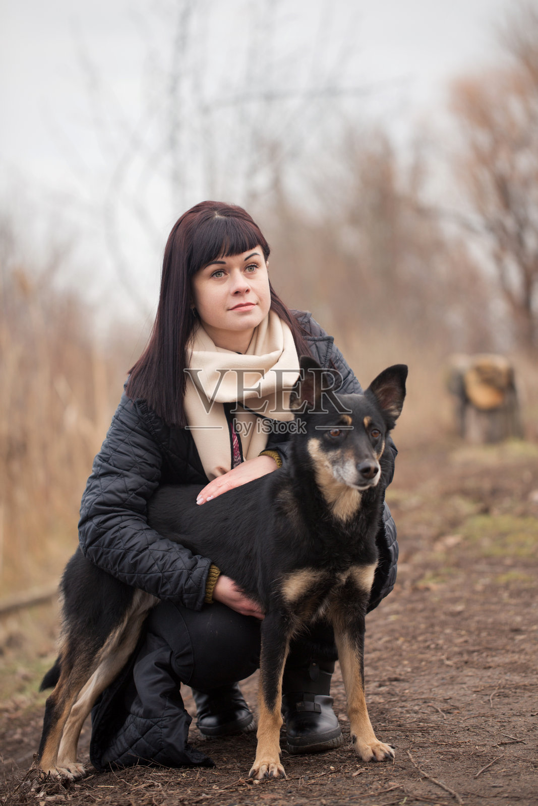 公园里一位女士抱着她的狗的肖像照片摄影图片