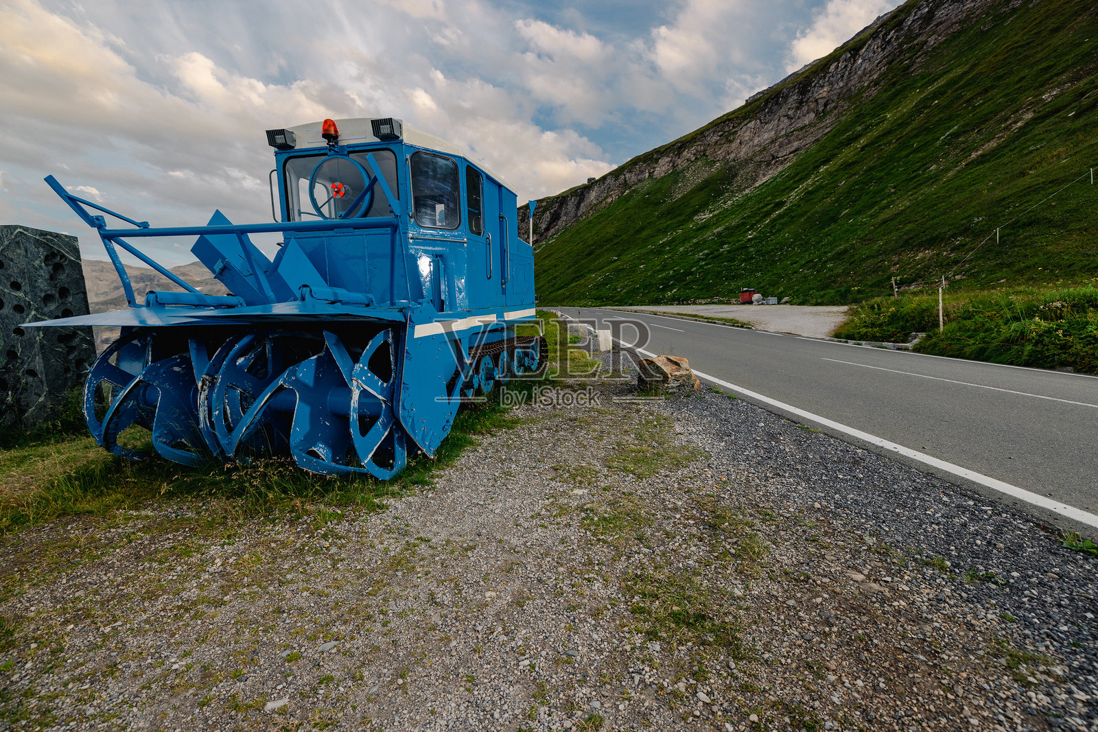 著名的旋转式雪犁在奥地利最高的阿尔卑斯山公路——格罗斯格洛克纳公路上。蓝色雪犁在盛夏中静静地停放。照片摄影图片