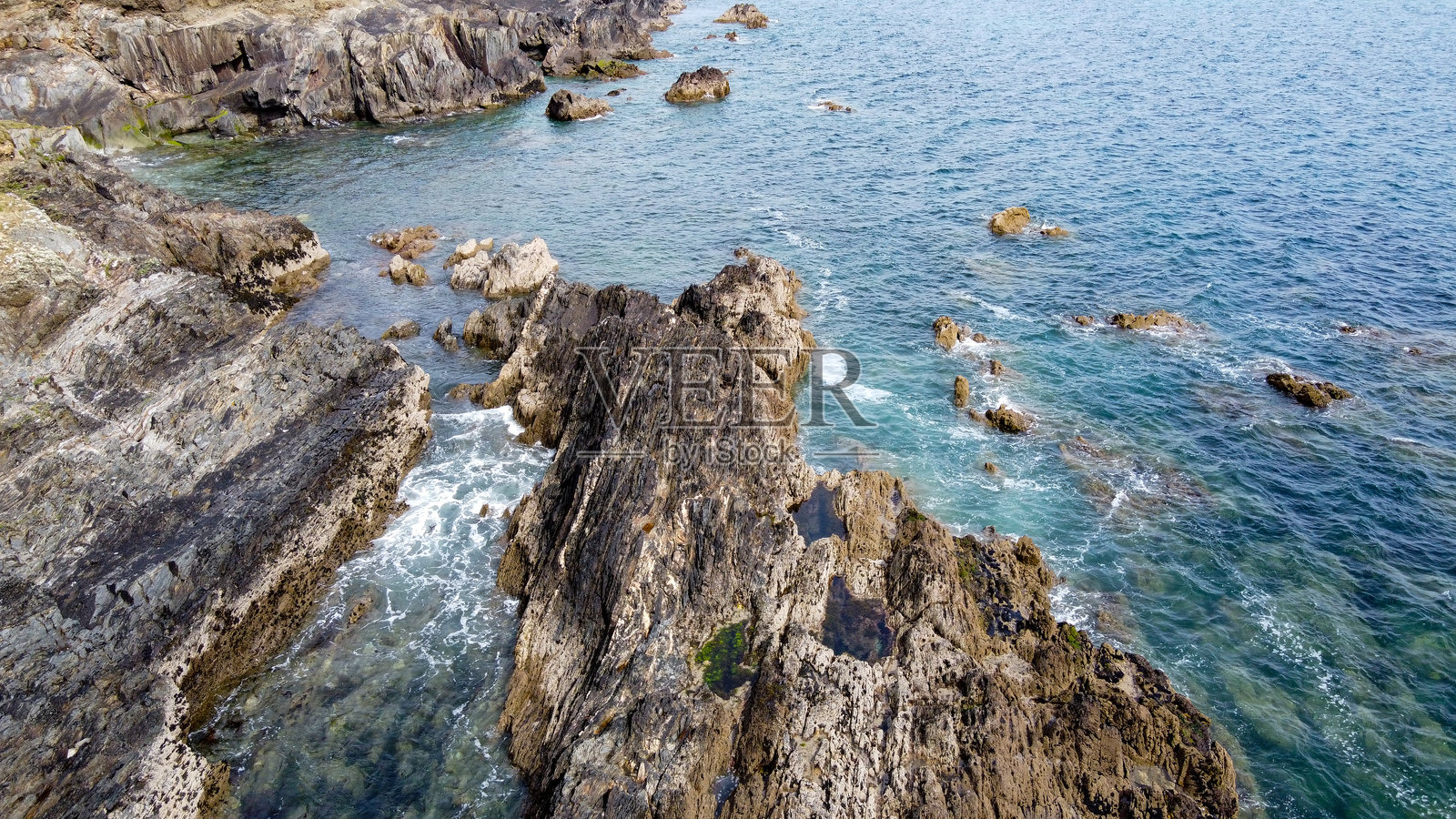 美丽的悬崖。波浪上的白色泡沫。海浪中的岩石。照片摄影图片