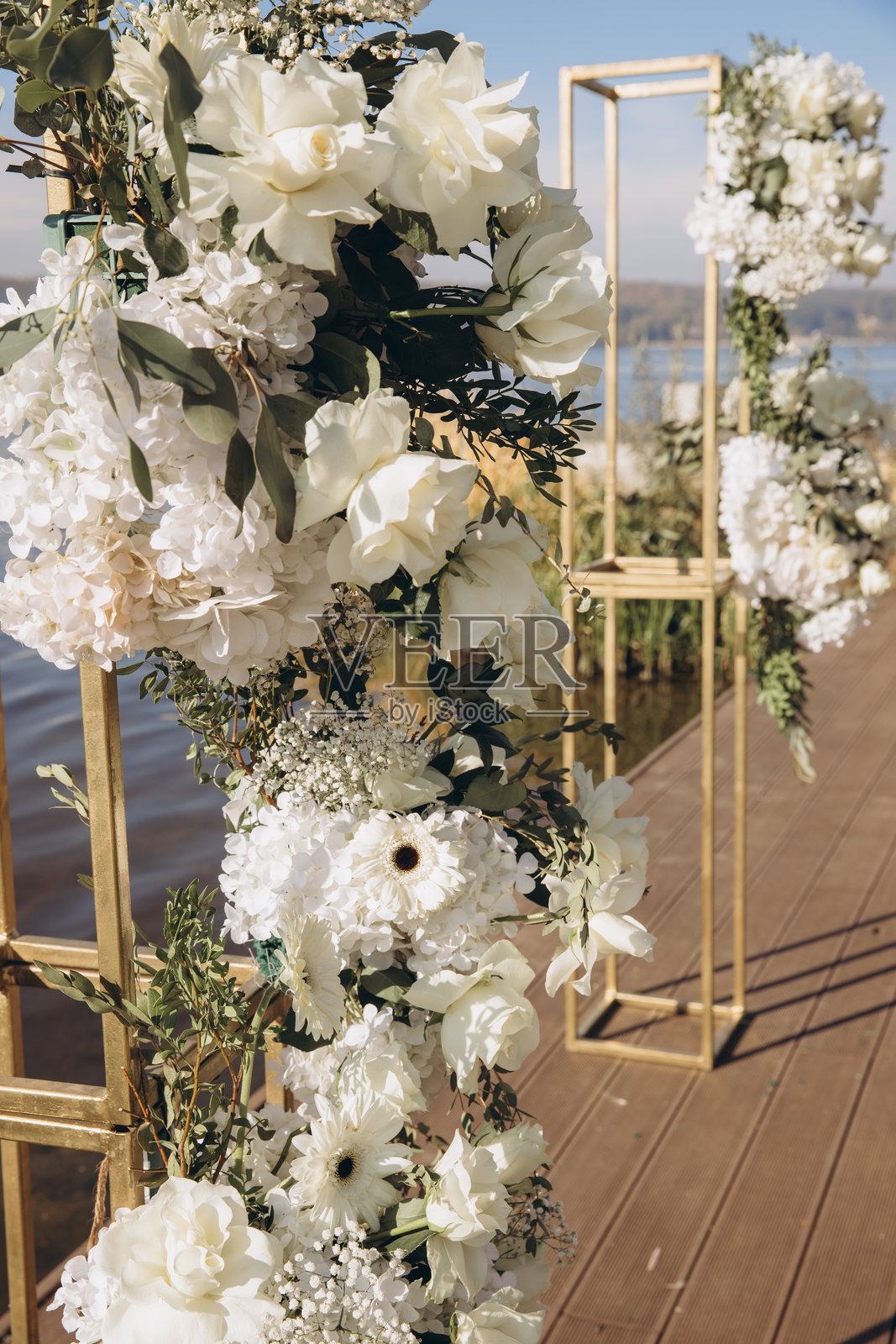 码头上装饰着白色花朵的婚礼仪式拱门照片摄影图片