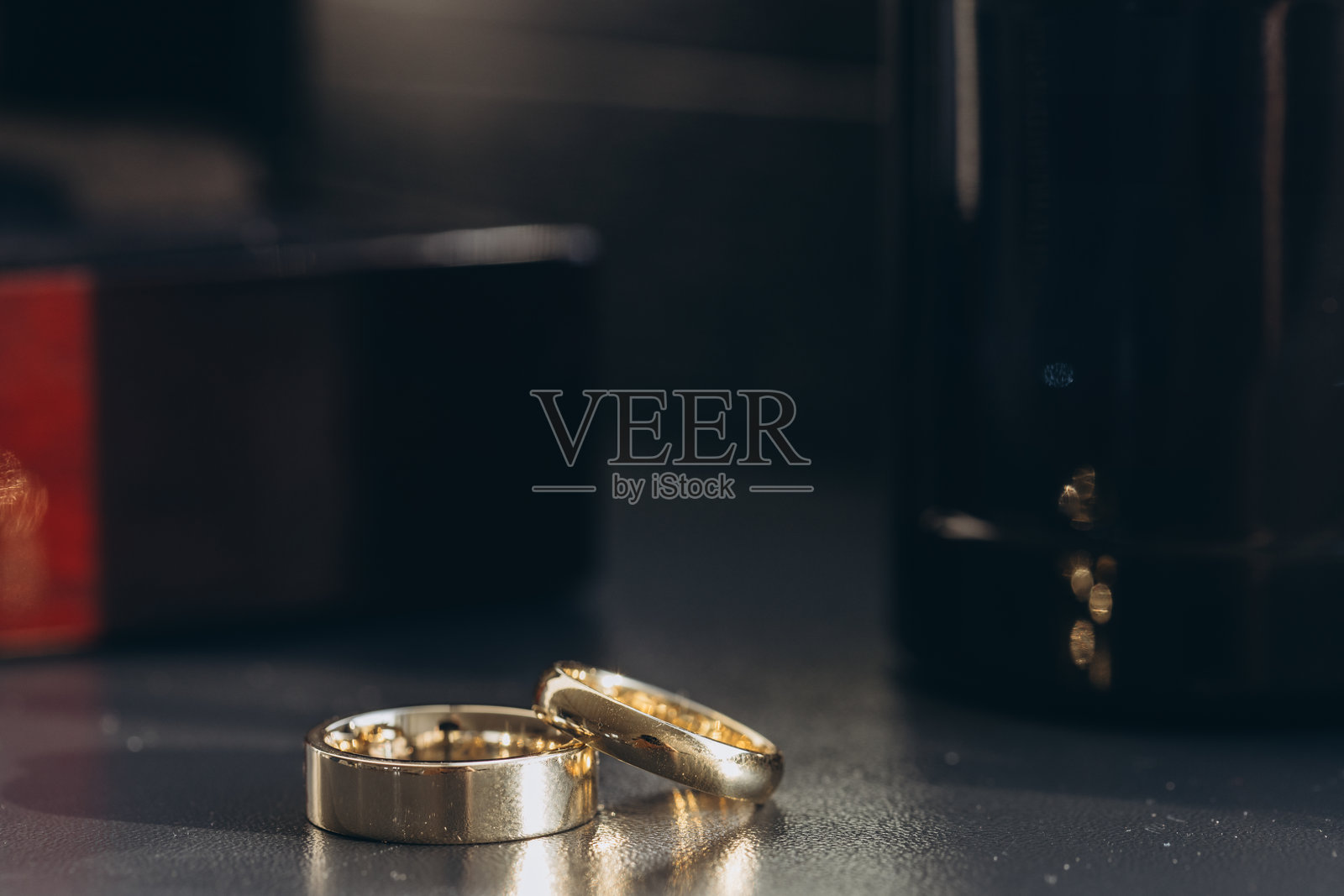 两枚金色婚戒静静地放在仪式前的桌子上照片摄影图片