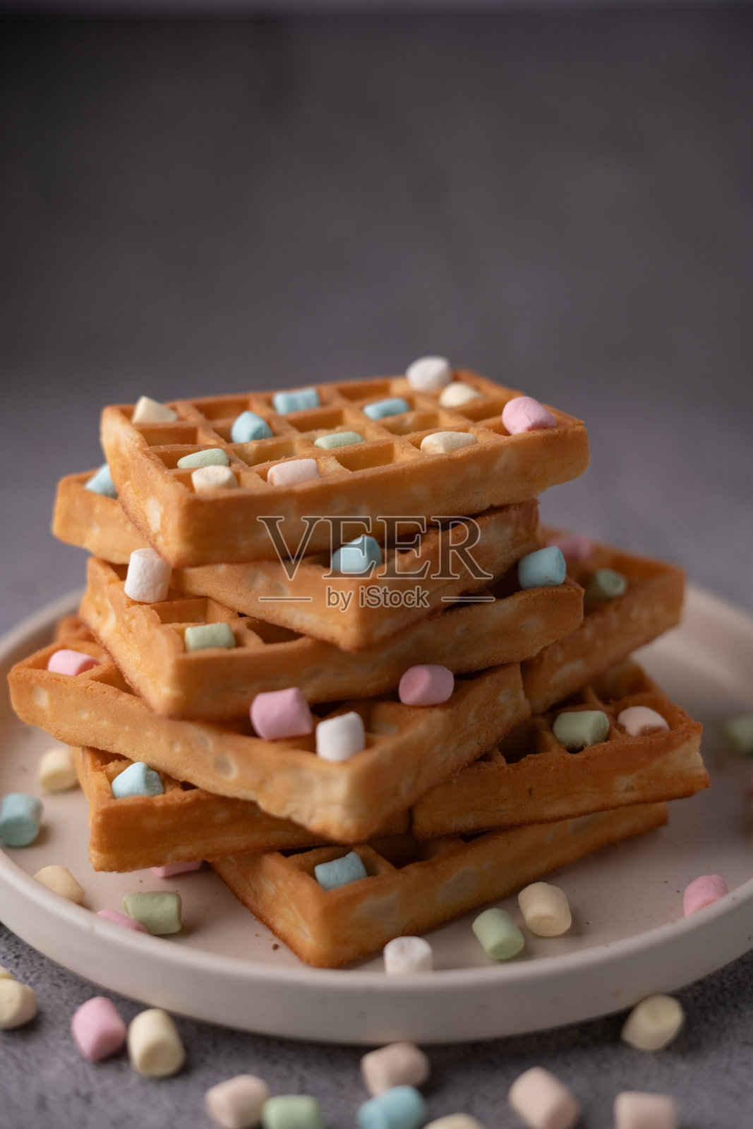 美味的金棕色华夫饼叠加上五彩缤纷的棉花糖，营造出适合各年龄段在家享用的甜美诱人早餐或小吃体验照片摄影图片