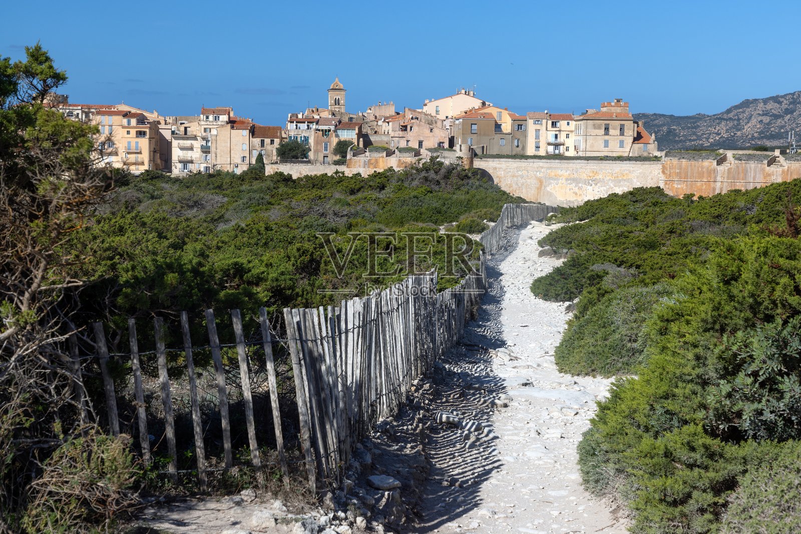 科西嘉岛历史悠久的博尼法乔，坐落在戏剧性的石灰岩悬崖上，背景是清澈的蓝色地中海海洋和天空。照片摄影图片