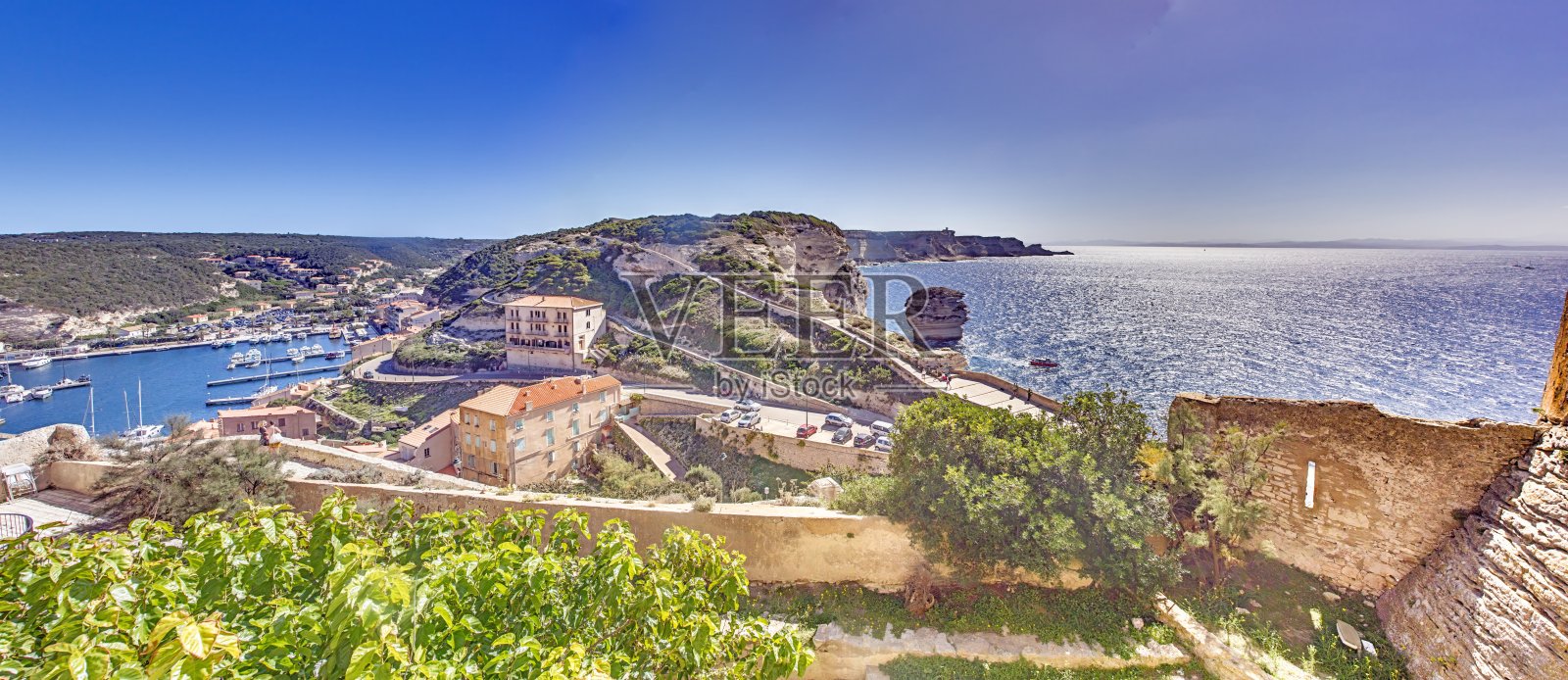 科西嘉岛历史悠久的博尼法乔，坐落在壮观的石灰岩悬崖上，背景是湛蓝的地中海海洋和天空。照片摄影图片