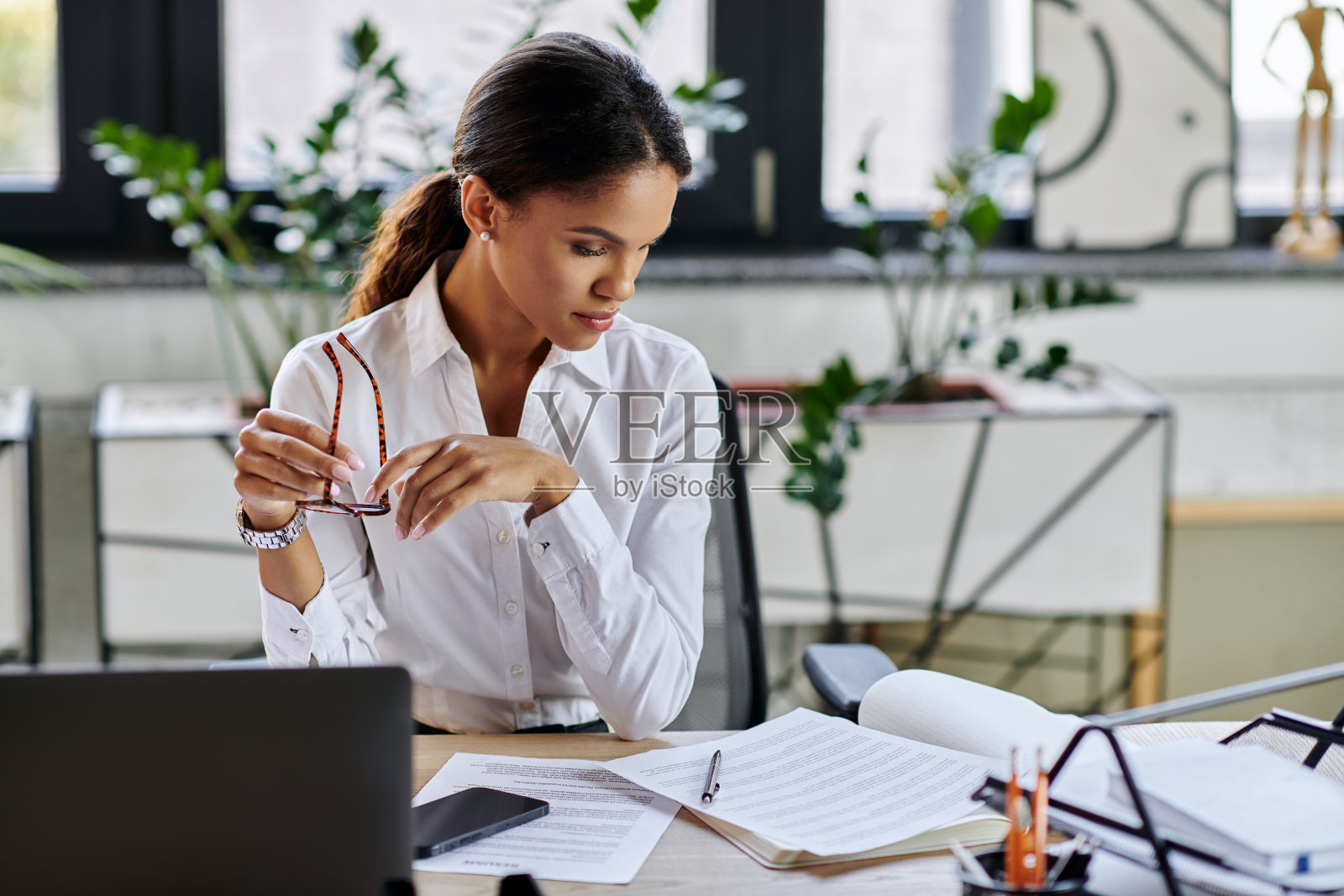 专注的年轻女商人在现代办公室环境中工作照片摄影图片