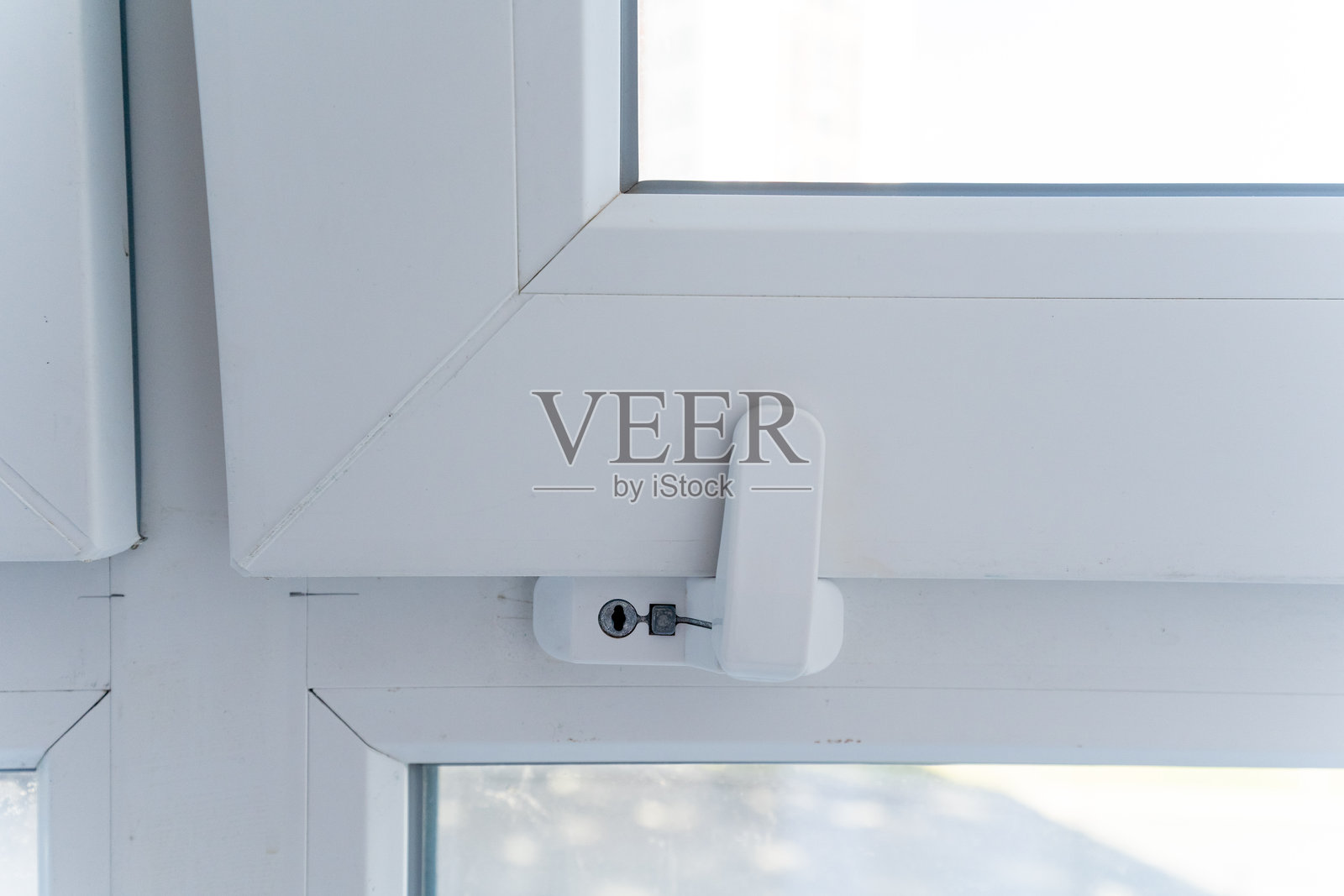 这张图片展示了一个洁白无瑕的窗户特写，窗户上配有安全锁，突显了其设计和在安全性与功能性方面的实用性。照片摄影图片