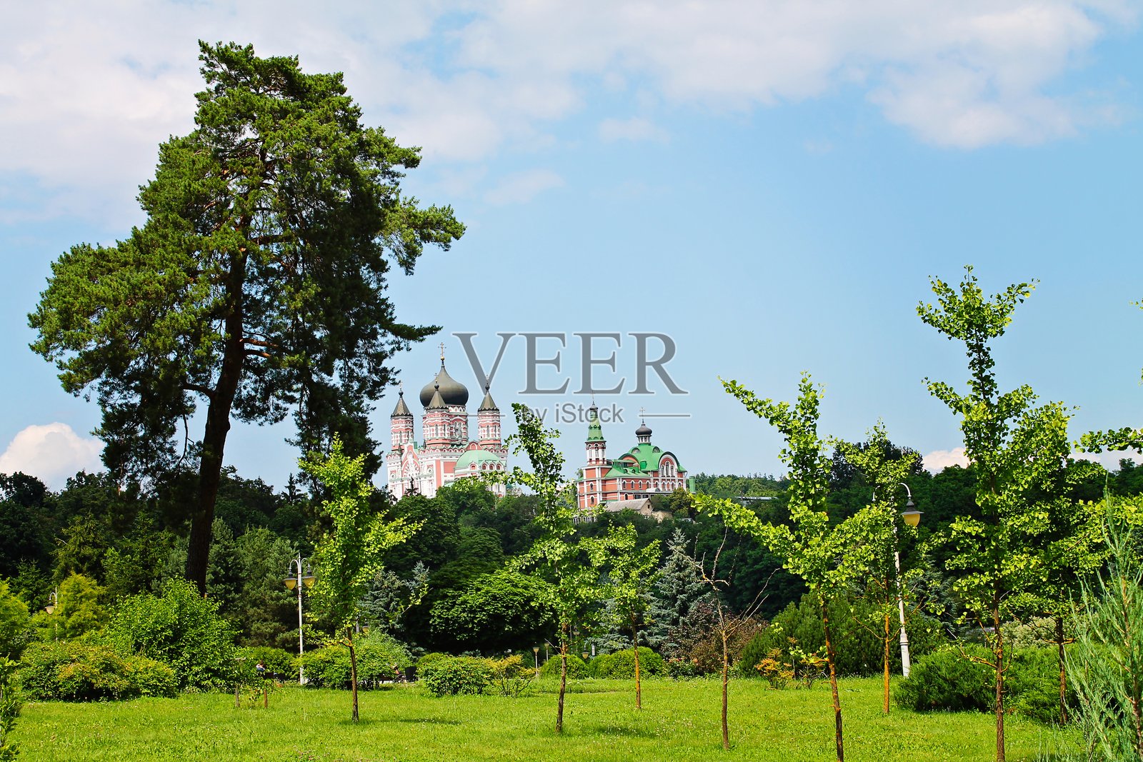 宏伟的修道院矗立在郁郁葱葱的绿树之上，捕捉到宁静的夏日山丘的平和本质。照片摄影图片