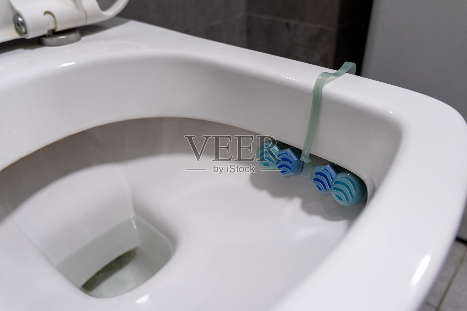 卫生间清洁程序中的马桶碗和悬挂式清新剂，用于保持卫生和控制气味照片摄影图片