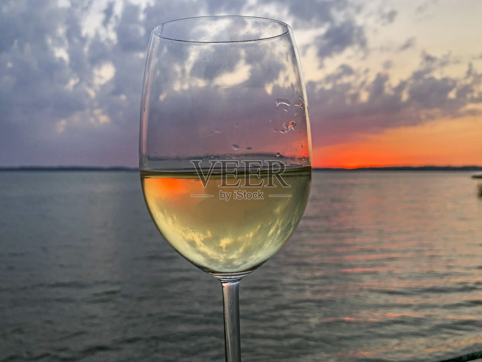 香槟酒杯中映照的日落余晖照片摄影图片