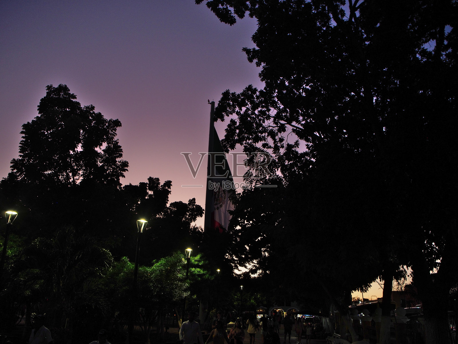 2023年11月20日黄昏时分，瓦拉多利德的墨西哥国旗（Bandera nacional de México）庆祝墨西哥革命日（Aniversario de Revolución Mexicana）。照片摄影图片