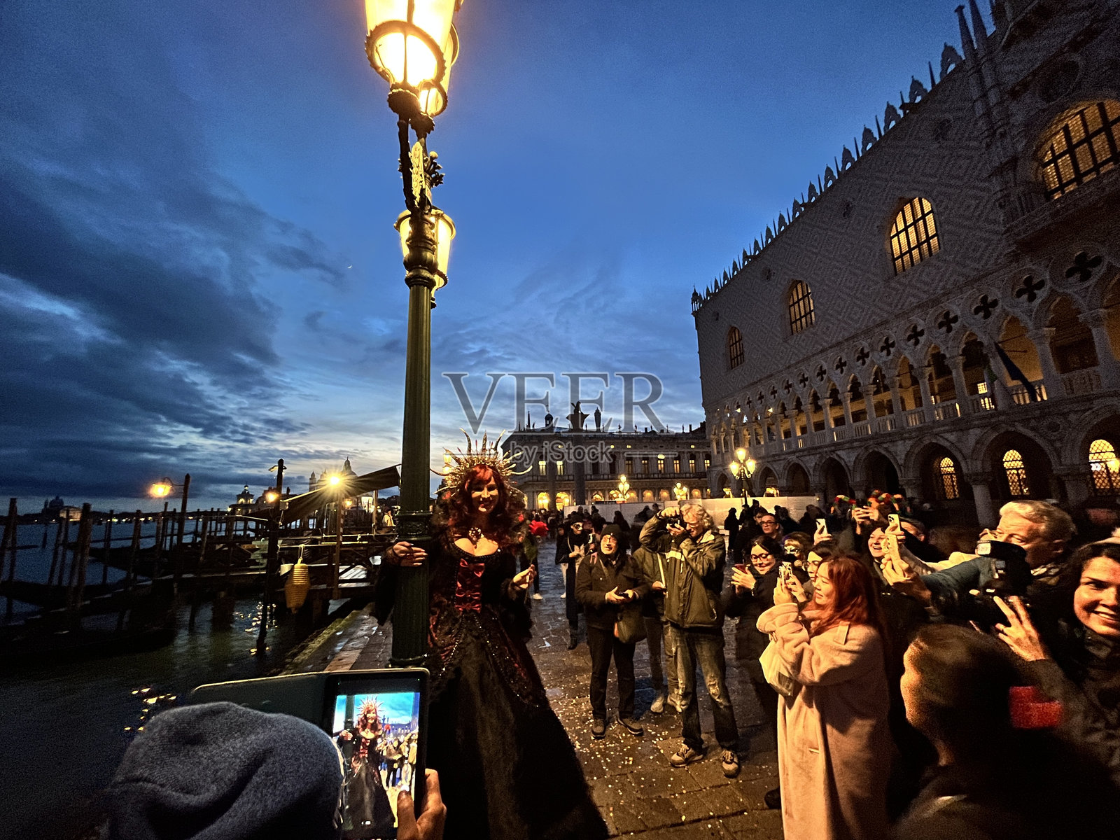 黄昏时分，身着华丽服装的女子在威尼斯狂欢节上摆姿势照片摄影图片