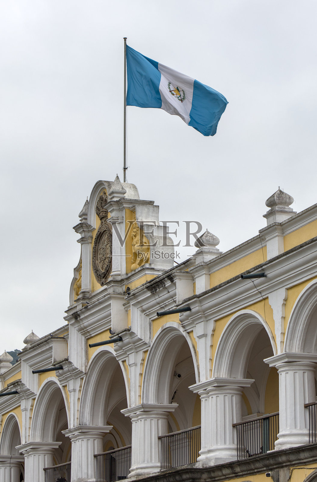 危地马拉国旗飘扬在安提瓜市中心著名的历史殖民西班牙建筑上（拉丁美洲国家的前首都）旅游旅行蓝白色横幅照片摄影图片