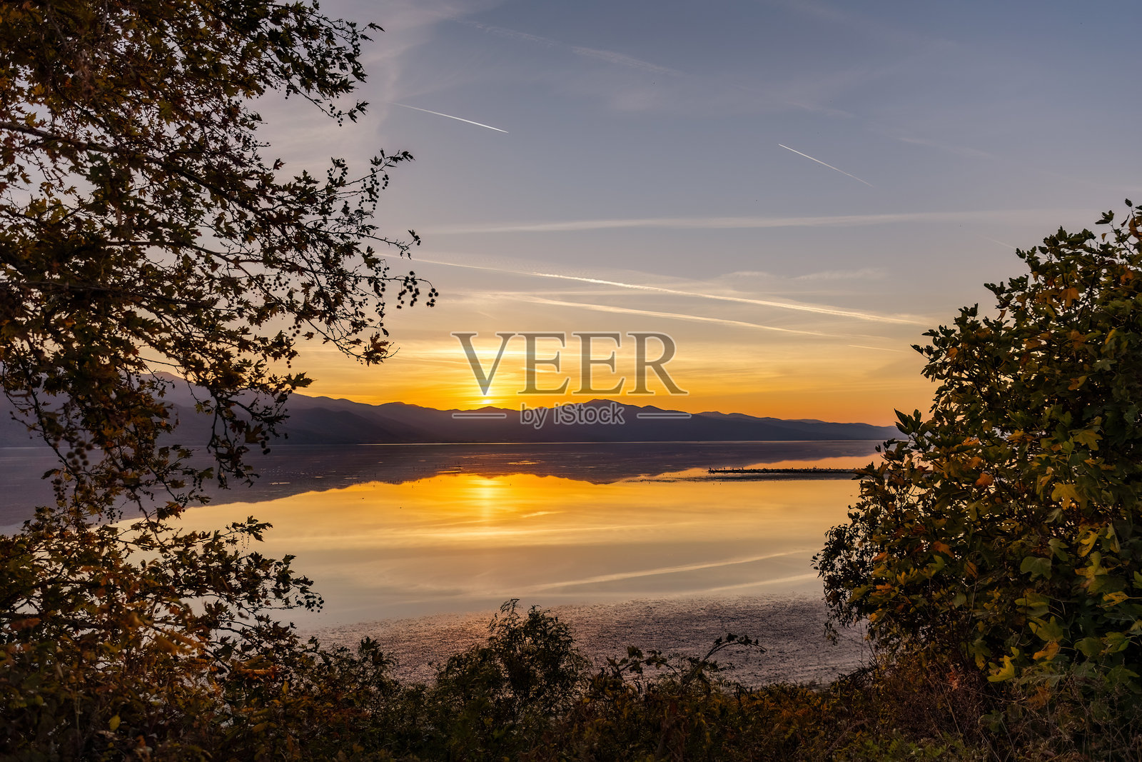 美丽的马其顿希腊克尔基尼湖日落景色，金色时光与日出，水面倒影，秋天的落叶照片摄影图片