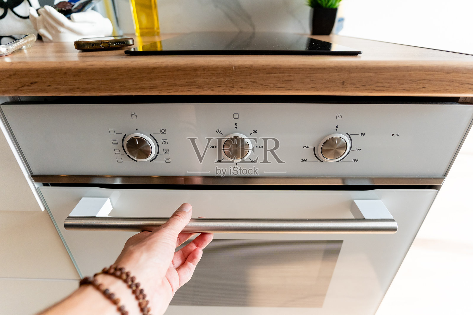 现代厨房烤箱配有美丽的木质台面和时尚的控制装置，非常适合优雅的烹饪体验。照片摄影图片