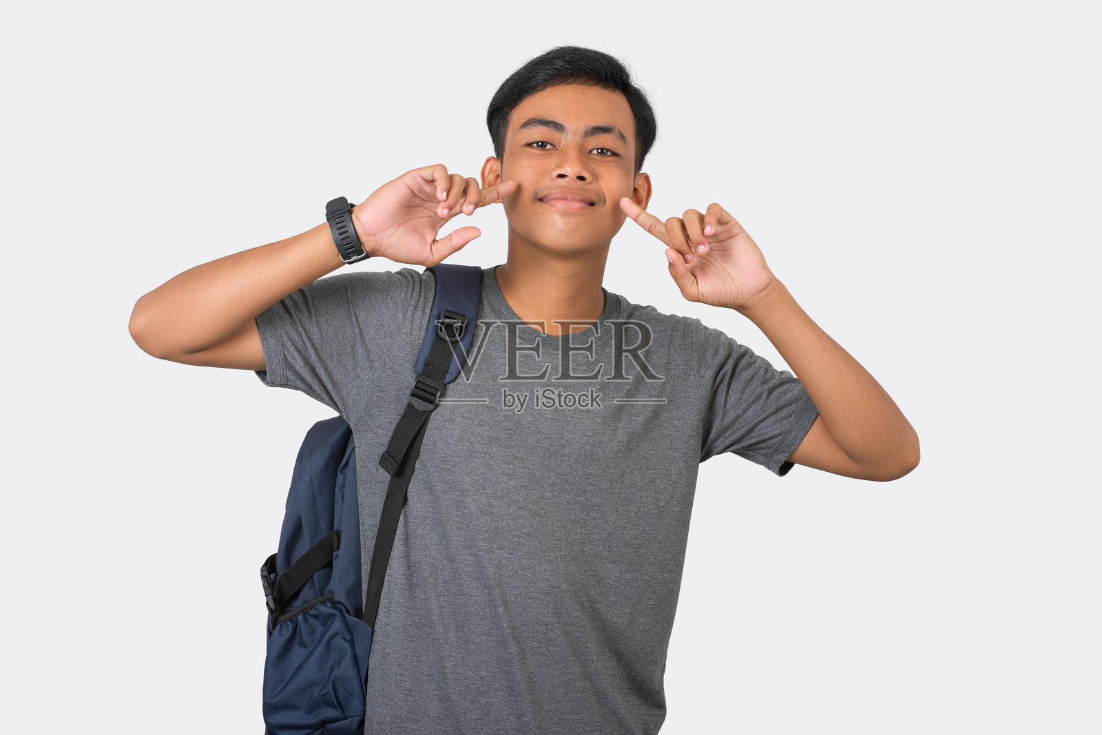 微笑的年轻大学生背着书包，准备上学，背景为白色。照片摄影图片