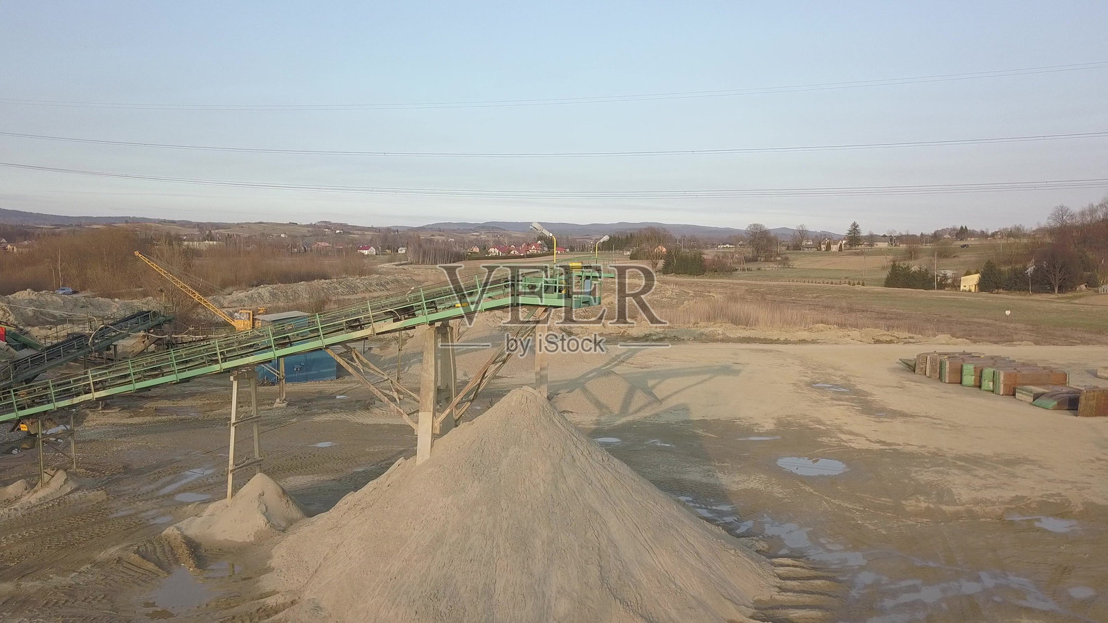 用于提取和分类碎石的设备元素。建筑材料的生产。用于处理石头和岩石的金属结构。输送带下的碎石渣。照片摄影图片