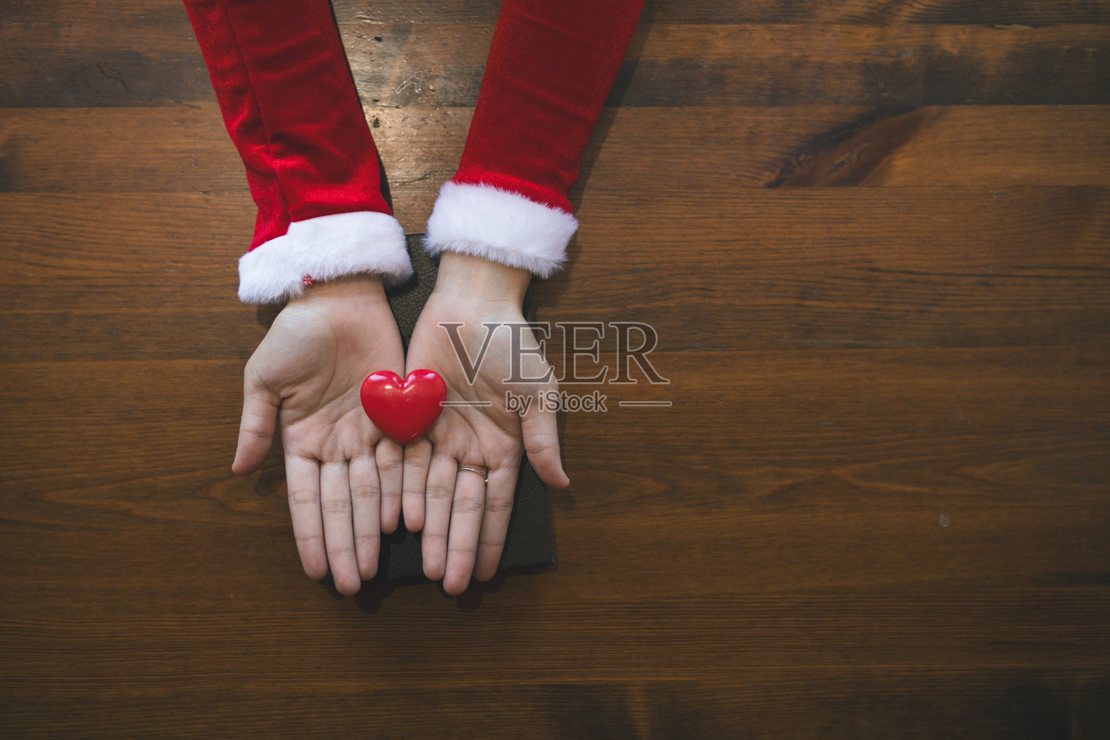 年轻女性手握心形符号，表达对朋友和爱人的爱与友谊，作为情人节的礼物。友谊与爱情的概念。照片摄影图片