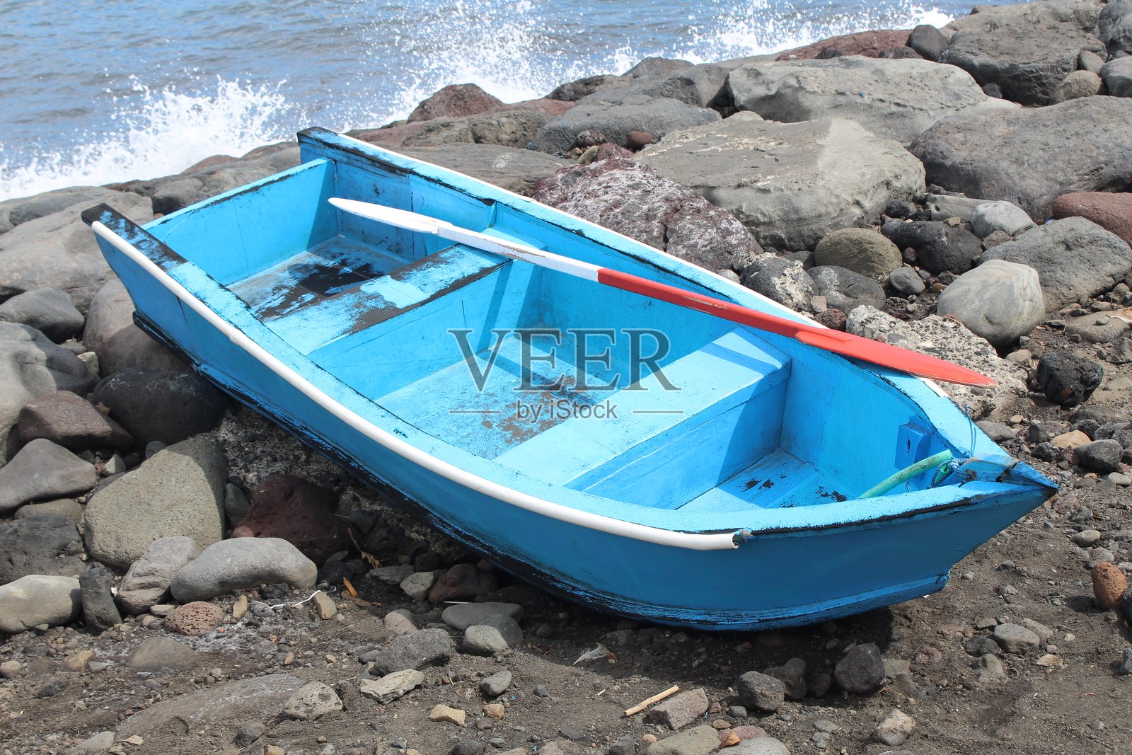 一艘船在岩石海滩上靠岸照片摄影图片