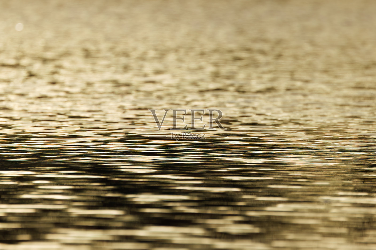 傍晚阳光下的池塘日落，金色湖面，橙黄色的日落色彩，金色结构，金色波浪图案，线条图案，凹槽结构，带波浪的金色背景照片摄影图片